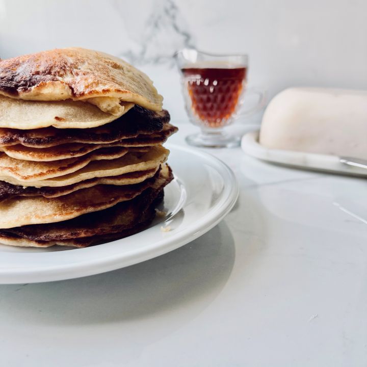 Stack of Fresh Milled Flour Pancakes with Cottage Cheese with syrup & butter dish in the background