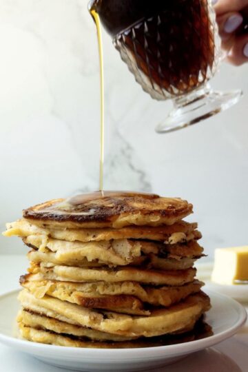 Stack of Freshly Milled Flour Pancakes with Cottage Cheese with syrup being poured on them
