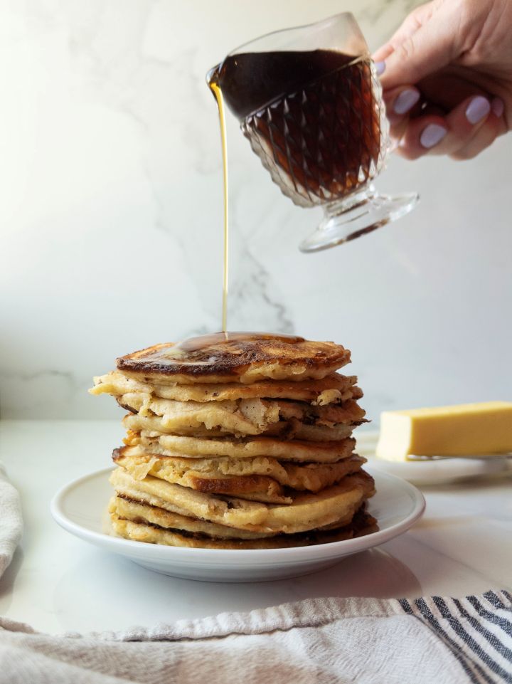 Stack of Freshly Milled Flour Pancakes with Cottage Cheese with syrup being poured on them