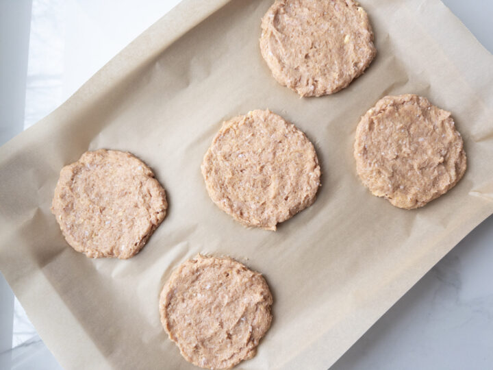 5 uncooked Gluten Free Turkey Burgers on a baking sheet