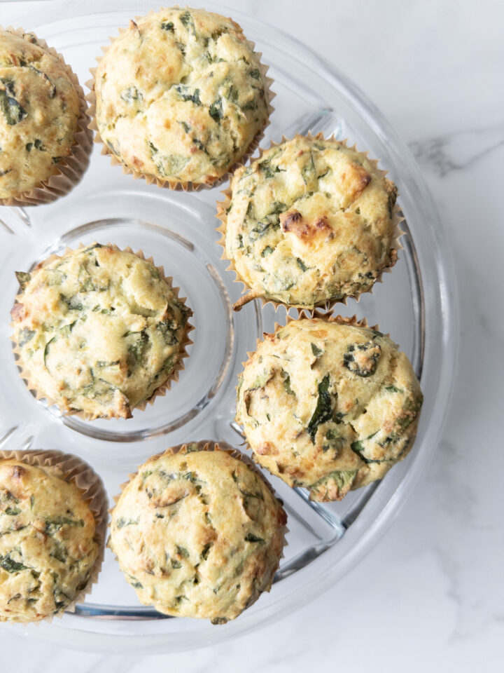 Savory Gluten-Free Spinach Feta Muffins sitting on a cake plate