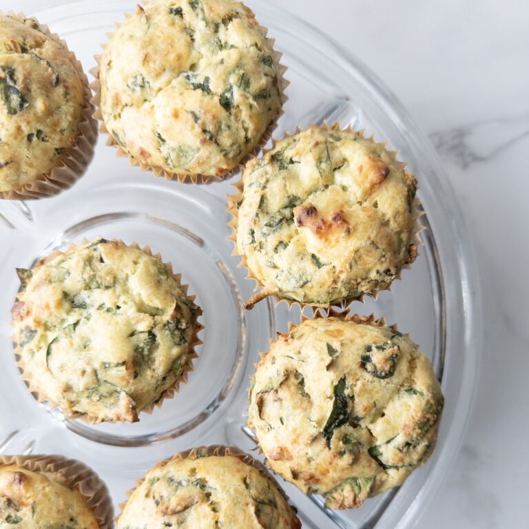 Savory Gluten-Free Spinach Feta Muffins sitting on a glass cake plate