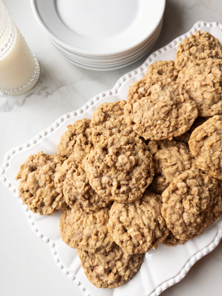 Platter of Soft & Chewy Oatmeal Butterscotch Cookies with Fresh Milled Flour with milk & plates in the background