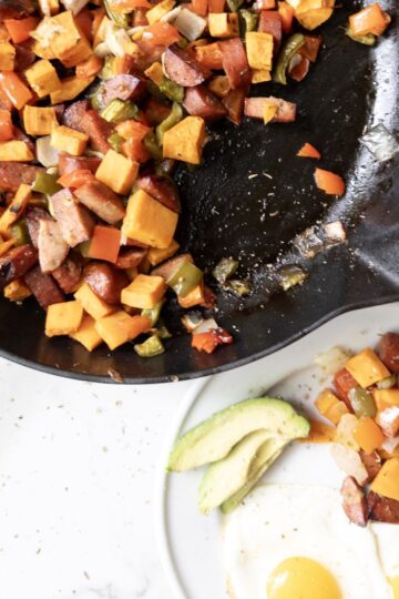 Sweet Potato & Chicken Sausage Skillet with a plate of skillet, eggs, and avocado on the side