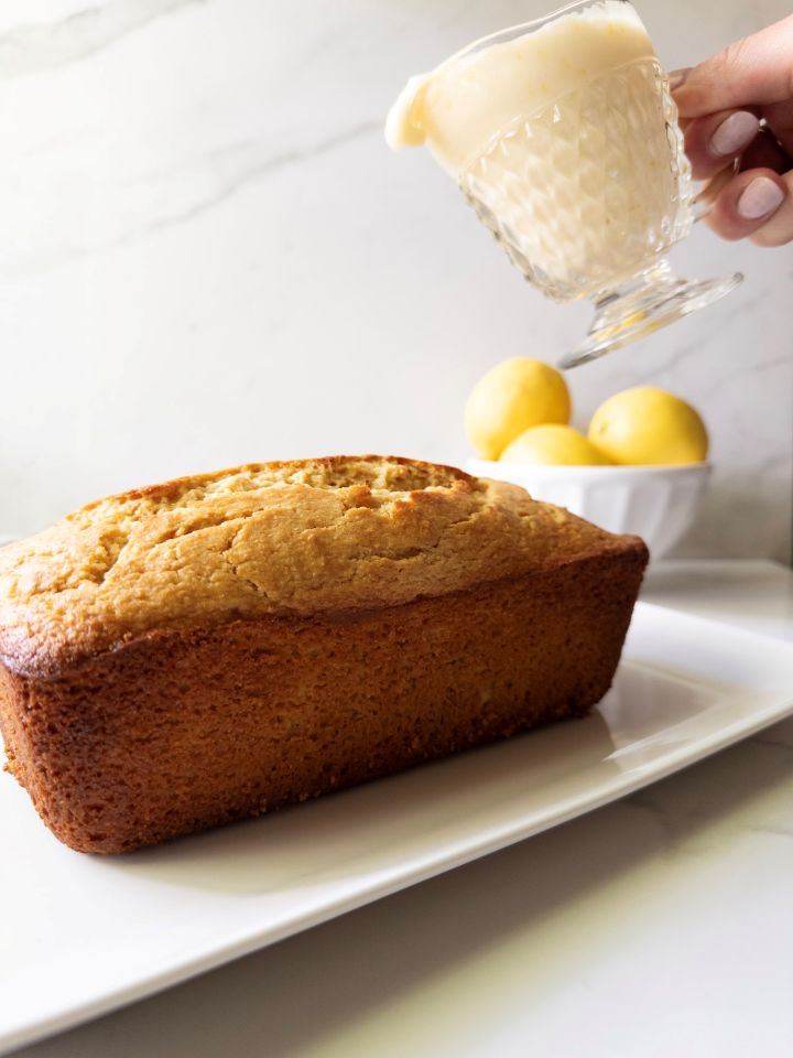 Pouring lemon icing over a fresh-milled flour lemon loaf