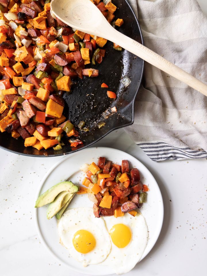 Sweet Potato & Chicken Sausage Skillet with a plate of skillet, eggs, and avocado on the side