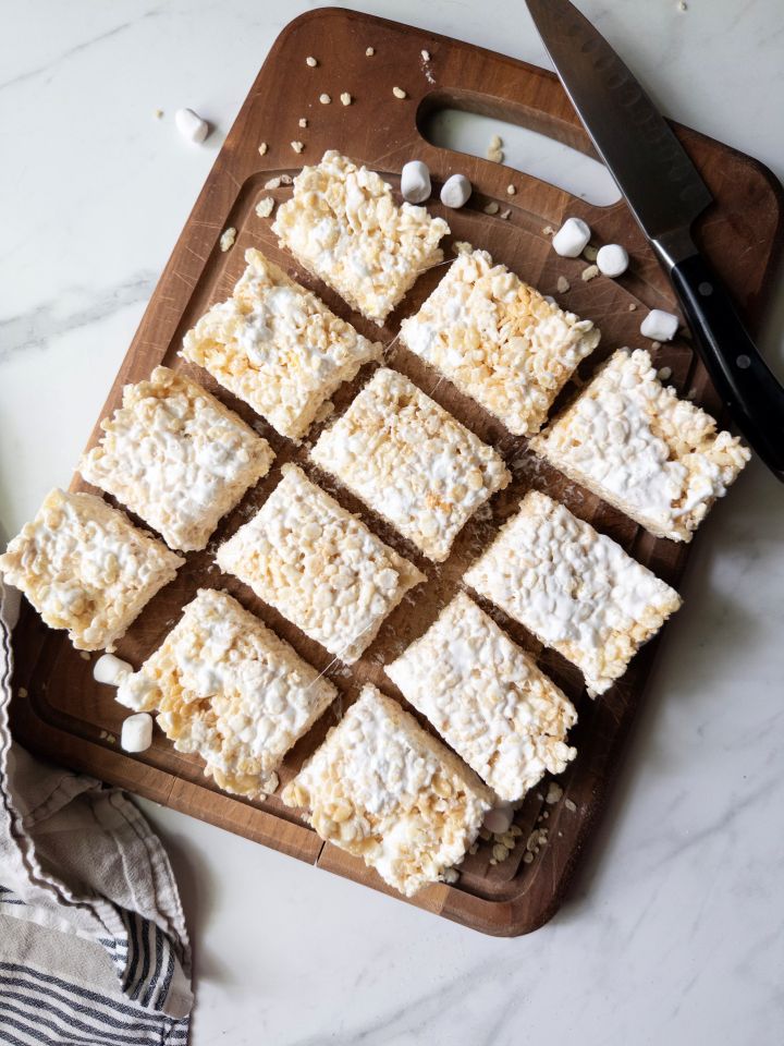 Thick and Gooey Rice Crispy Treats cut on a wooden cutting board