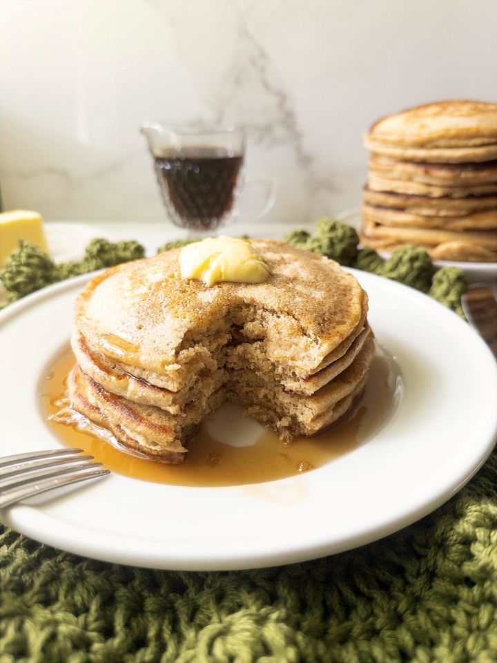 Fresh milled flour buttermilk pancakes served with butter and maple syrup with a bite taken out