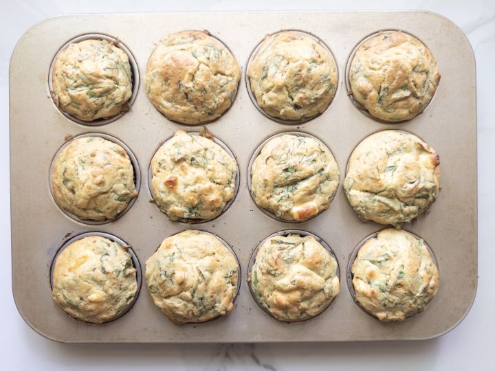 Baked spinach and feta muffins made with fresh milled flour cooling in the muffin tin